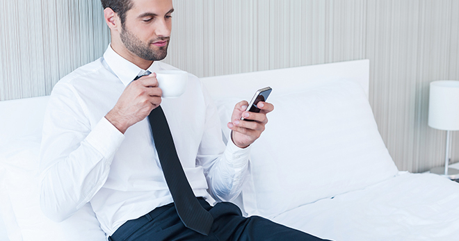 Man sitting on the bed using Mobile Phone